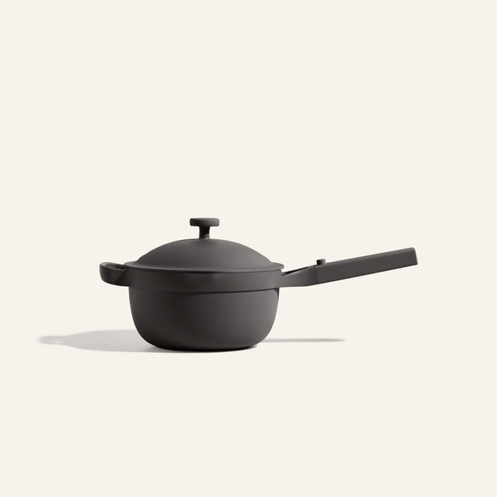 The Mini Perfect Pot 2.0, a matte black multifunctional pot with a lid and long handle, is displayed against a plain off-white background.