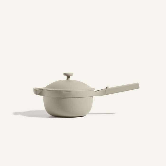 The Mini Perfect Pot 2.0 is a beige, nonstick pot with a matching lid and long handle, displayed against a plain light background.
