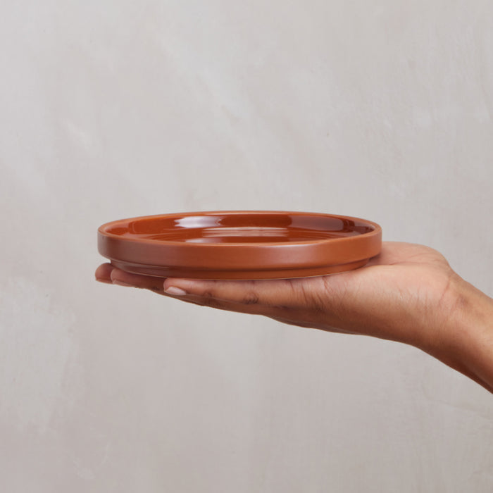 Single terracotta dessert plate on hand