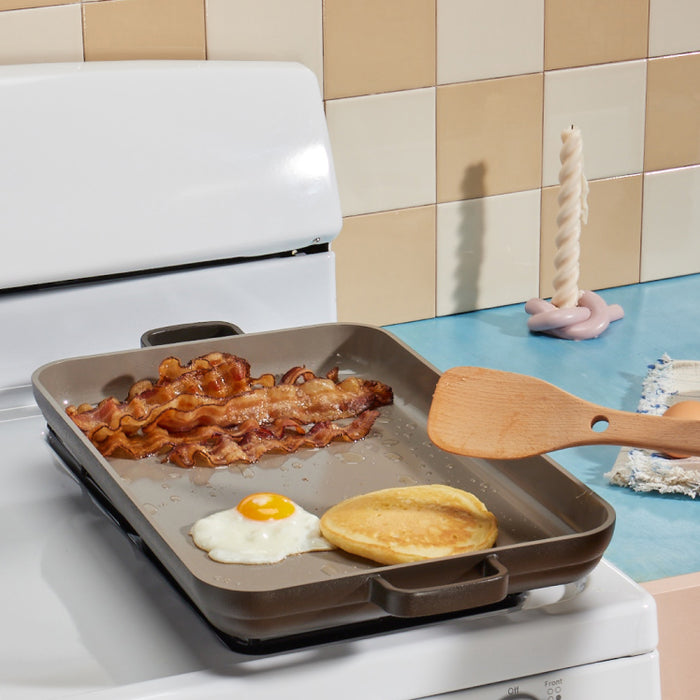 Griddle Pan with bacon and egg and pancake on stovetop