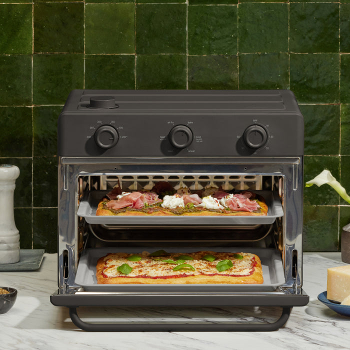 black large wonder oven non toxic air fryer toaster oven on counter cooking pizza on two trays