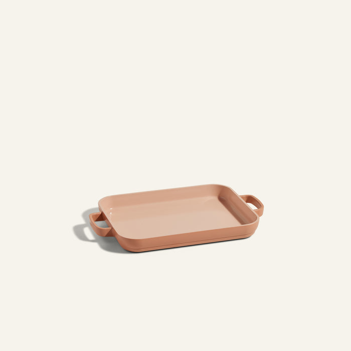 A Mini Griddle Pan in peach, rectangular and quarter-sized with dual side handles, is displayed against a plain off-white background.
