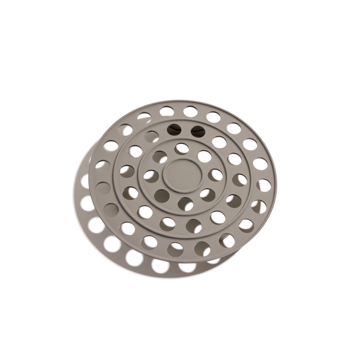 The Perfect Pot Roasting Rack is a round, gray rack with multiple concentric rings and circular holes, shown casting a shadow on a white background.