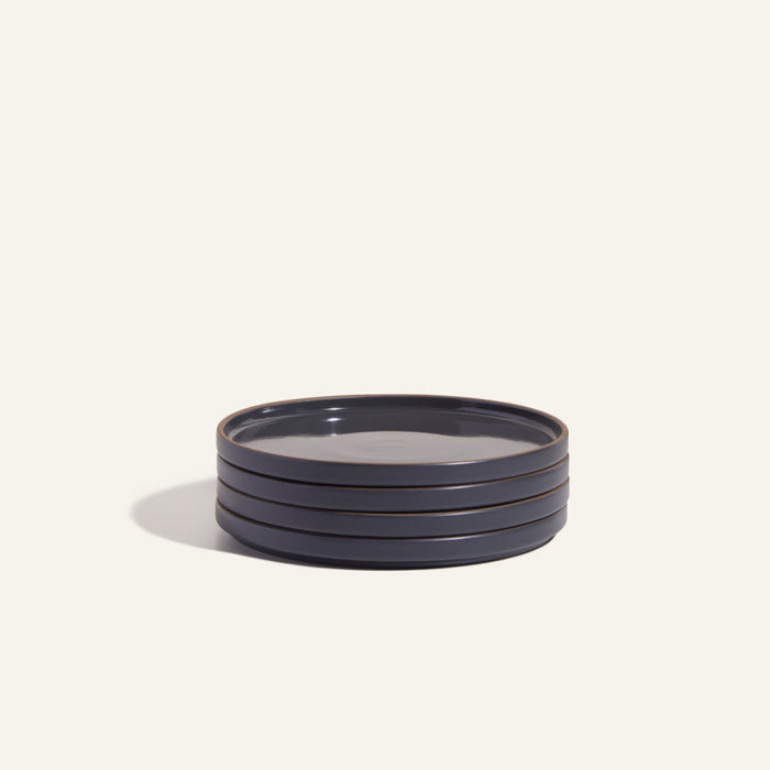 A set of four round, dark blue Salad Plates is displayed on a light background, showcasing elegantly crafted hand-glazed tableware.